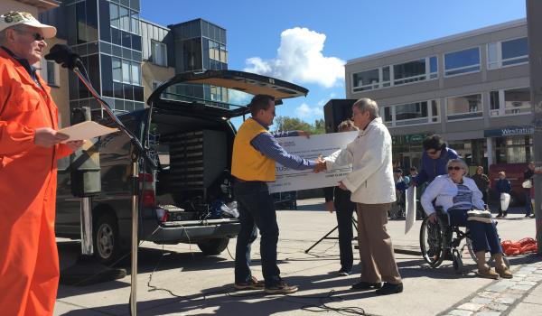 Kommande president Ari Valtonen överräcker checken på 1000 euro till Västra Nylands Cancerklubb.