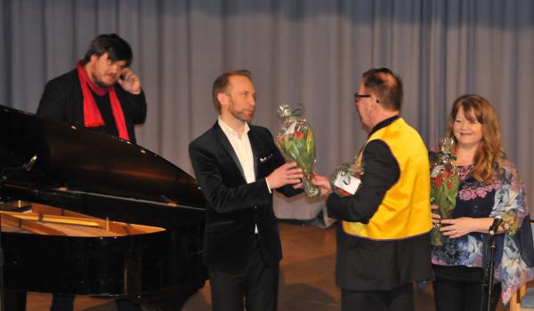 Klas Dalqvist överräcker blommor till artisterna (foto: Magnus Björkholm)